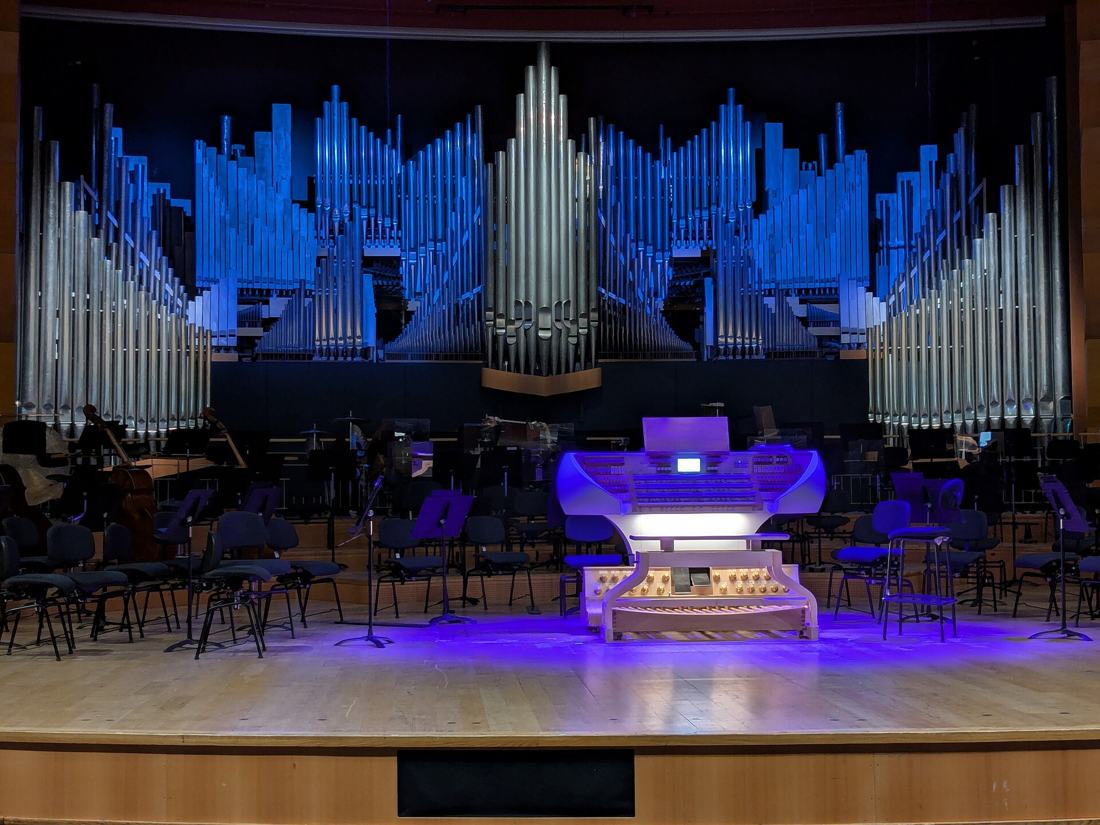 La scène de l'Auditorium de Lyon avec les pupitres de l'orchestre et l'orgue Cavaillé-Coll éclairé en bleu au fond