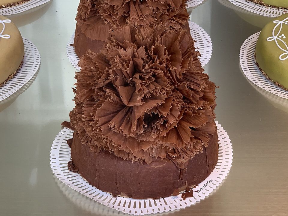 Un gâteau Président de Bernachon couvert de grands copeaux de chocolat, en vitrine