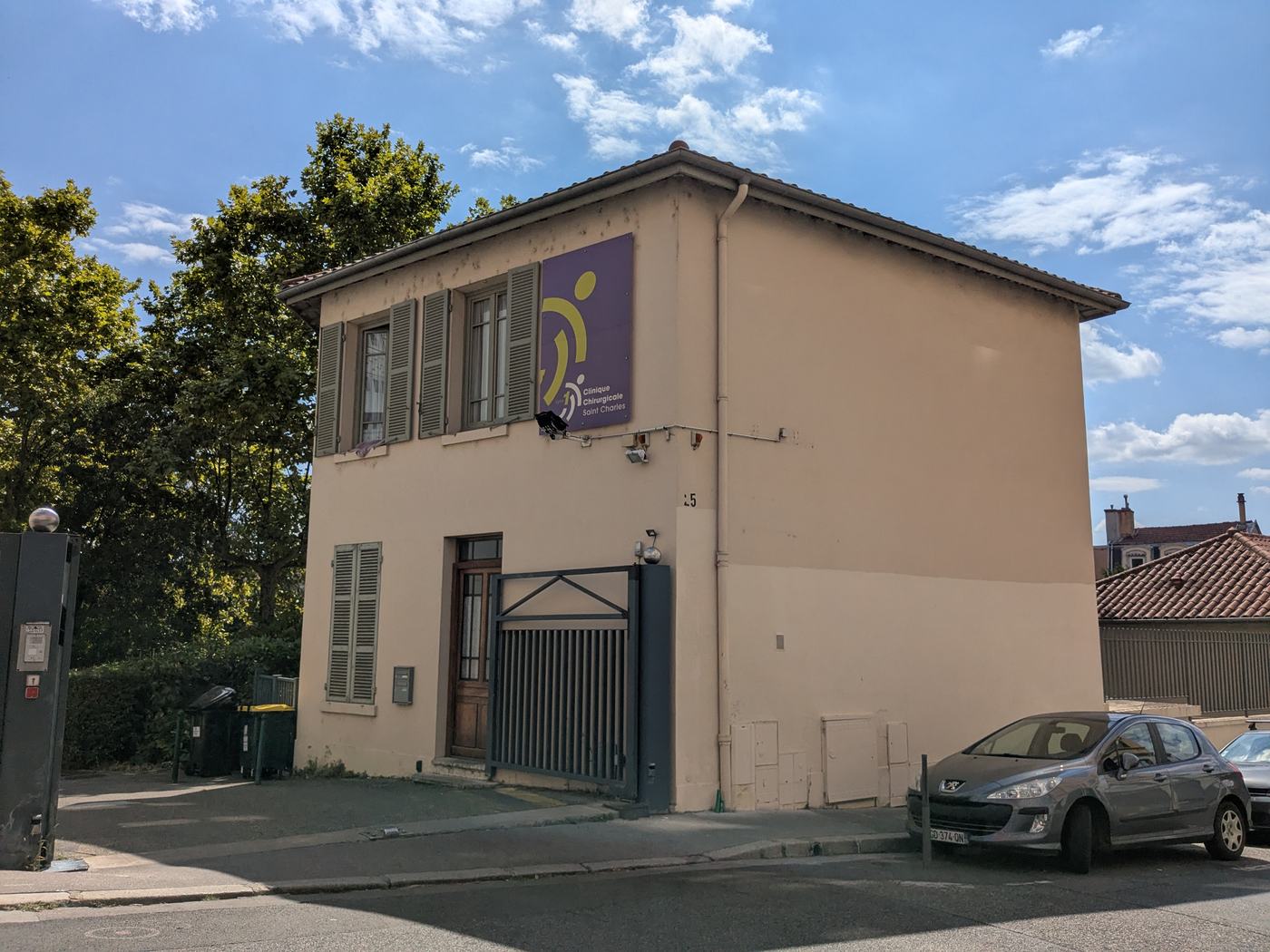 Entrée de la clinique chirurgicale Saint-Charles, rue de Flesselles à Lyon 1er : un petit bâtiment beige à volets, portant l'enseigne violette de la clinique