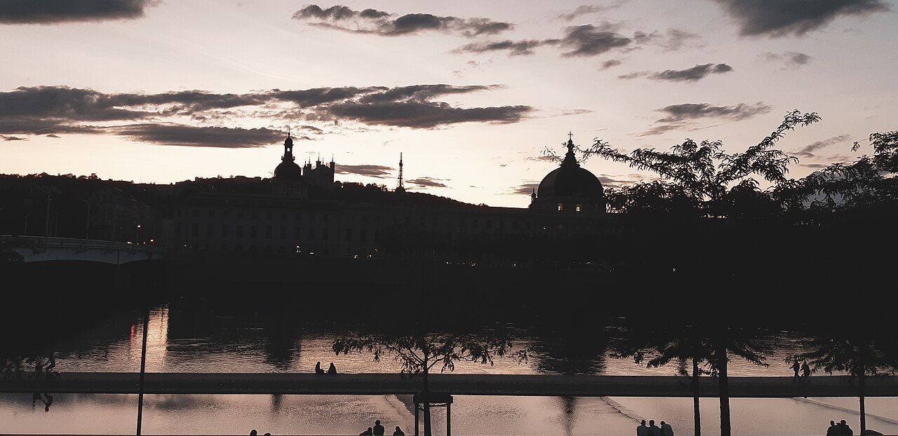 Silhouette de l'Hôtel-Dieu et de la colline de Fourvière au coucher du soleil, vue depuis les berges du Rhône