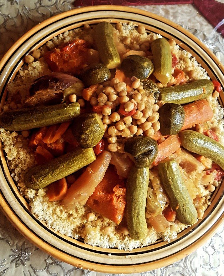Un couscous marocain servi dans un grand plat, semoule surmontée de légumes disposés en dôme