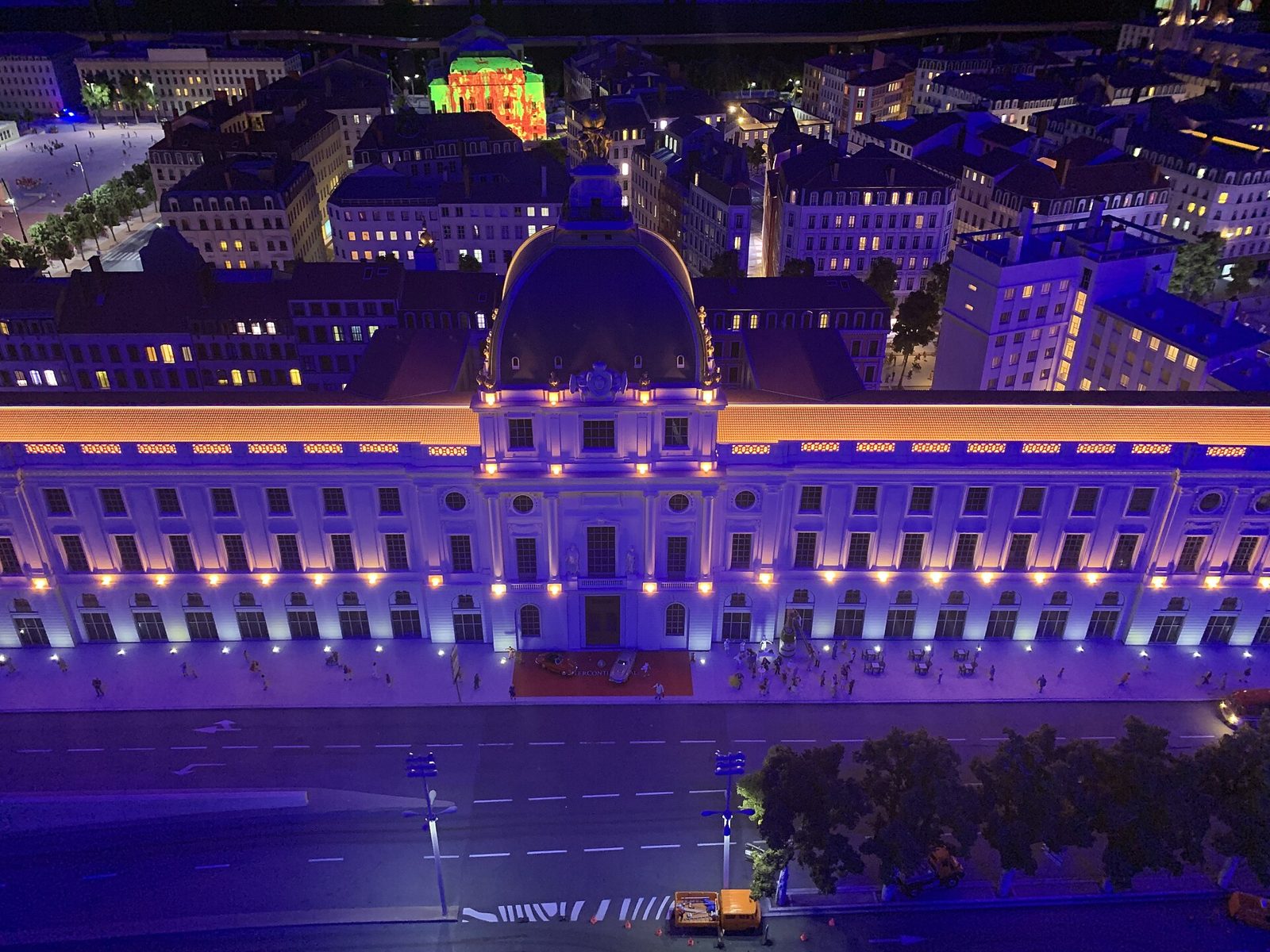 La maquette de l'Hôtel-Dieu de Lyon à Mini World pendant la phase de nuit, façade éclairée et fenêtres allumées sous un éclairage bleu