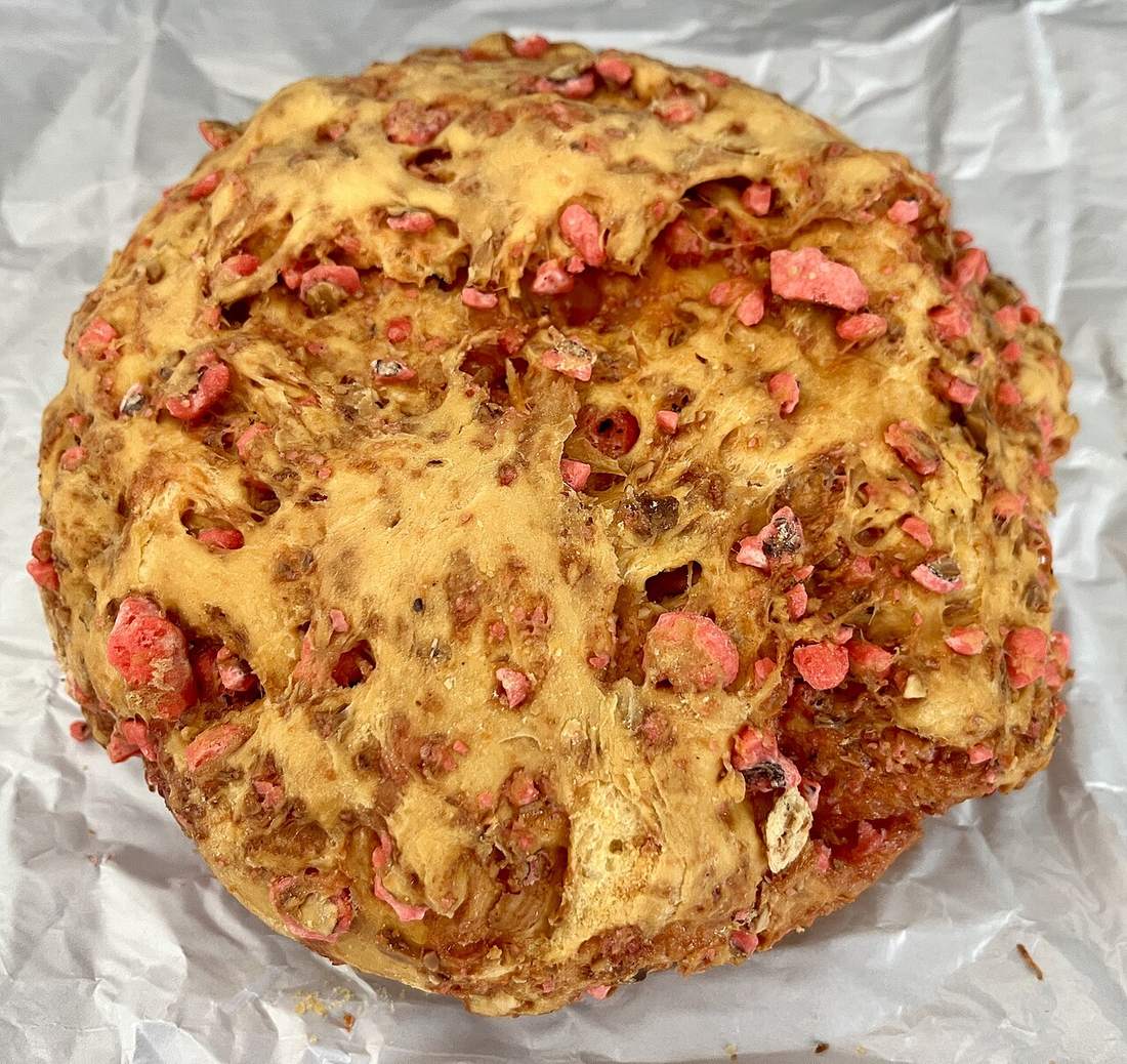 Une Praluline vue de dessus, brioche dorée constellée de gros éclats de pralines roses