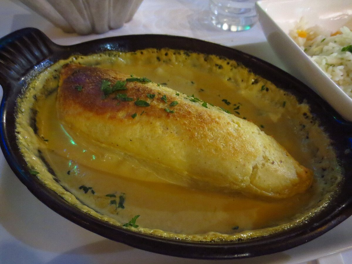 Une quenelle lyonnaise de brochet gratinée, nappée de sauce Nantua rose orangé