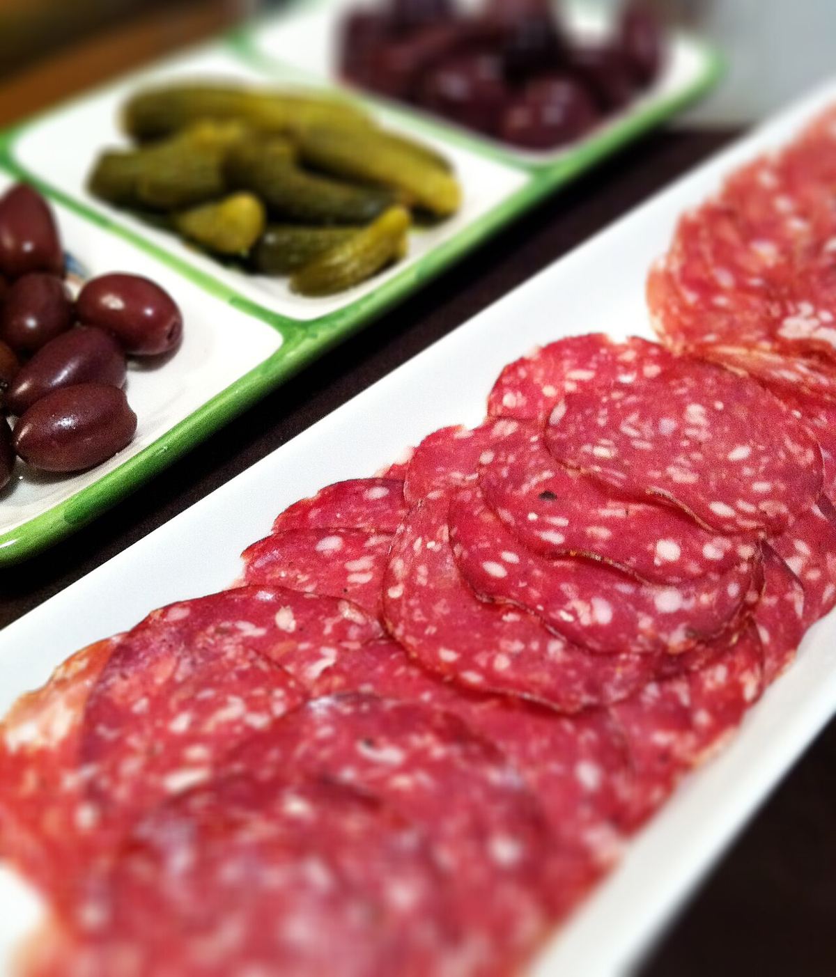 Une rosette de Lyon entière, saucisson sec au boyau plissé, suspendue