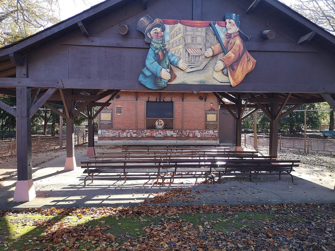 Le théâtre de Guignol du parc de la Tête d'Or, un castelet de bois ouvert sur l'extérieur avec ses bancs alignés